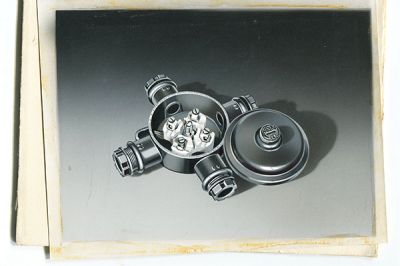 (Product illustration from the 60s. Round junction box made of thermosetting plastic Duroplast with four cable entries and one cover screw.)